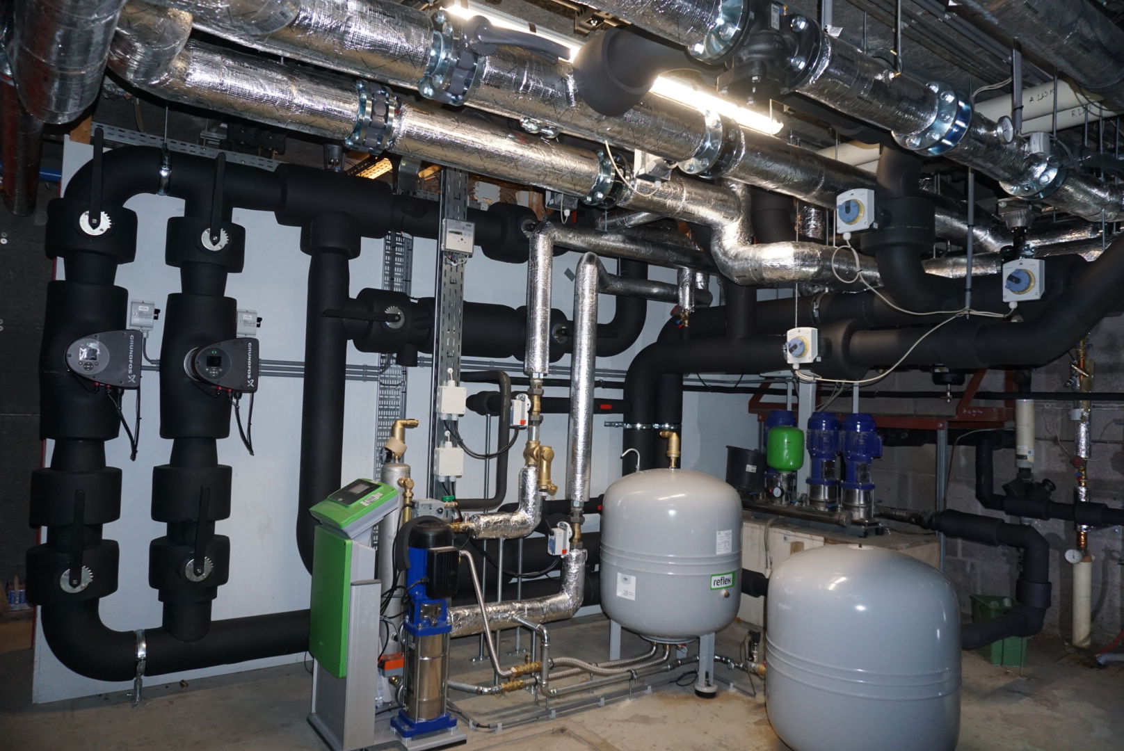 Technische ruimte met nette leidingisolatie, HVAC-kanalen en pompinstallatie door Elvon Isolatie